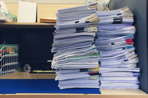 Pila de documentos sin terminar en el escritorio de oficina