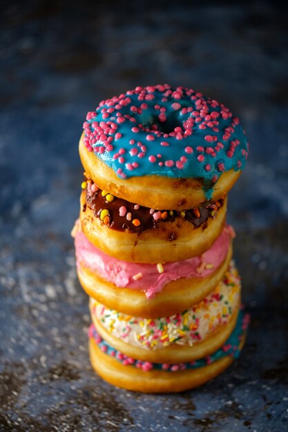 Pila de donuts de colores surtidos en una oscuridad.