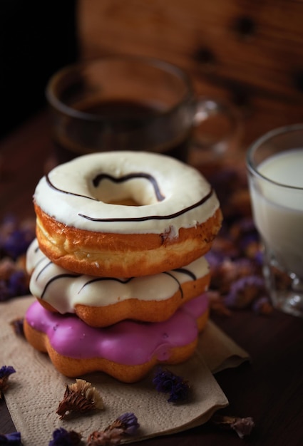 Una pila de donuts con glaseado blanco y glaseado rosa.