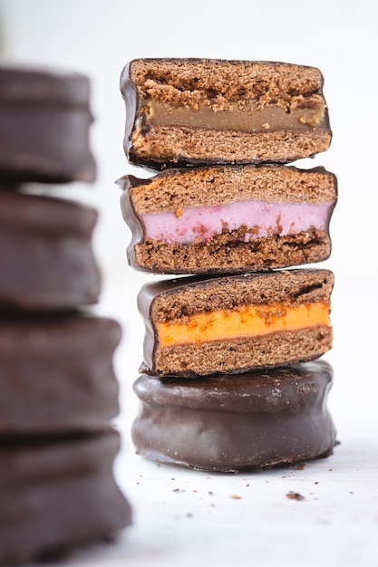 Pila de galletas cubiertas de chocolate con diferentes sabores de rellenos