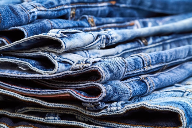Una pila de jeans como fondo de mezclilla o concepto de compra venta de compras y ropa moderna de moda