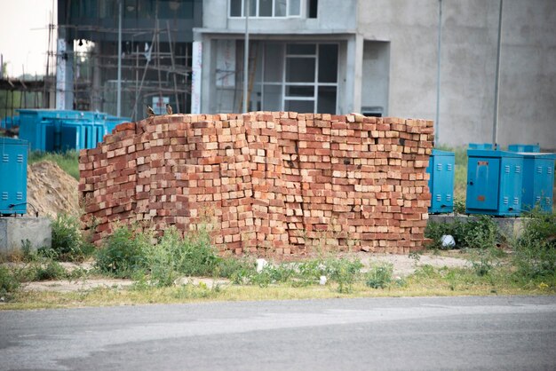 Pila de ladrillos rojos en el sitio de construcción