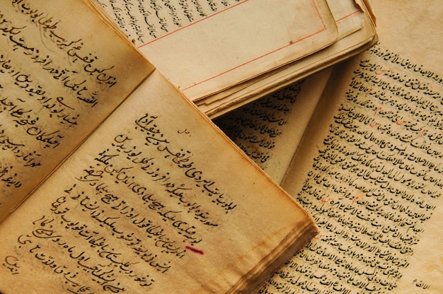 Pila de libros antiguos abiertos en árabe. Antiguos manuscritos y textos árabes. Vista superior