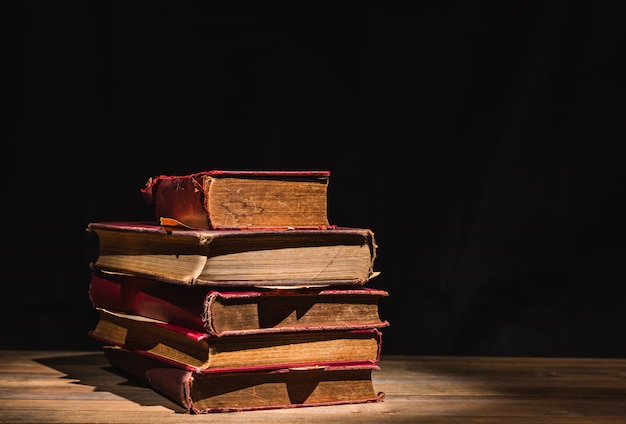 Pila de libros antiguos en mesa de madera