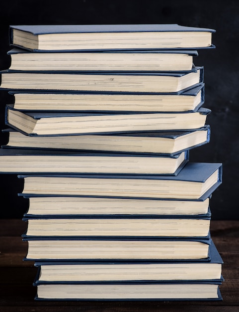 Pila de libros en una cubierta azul en una mesa de madera marrón