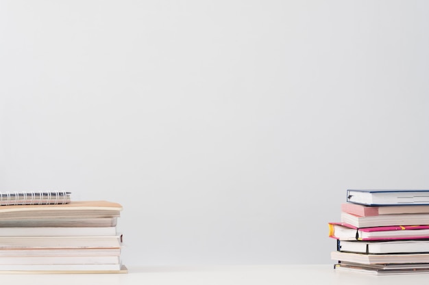 Pila de libros en el escritorio sobre blanco.