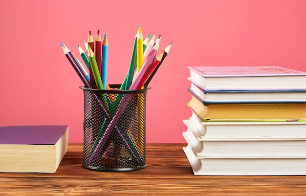 Una pila de libros, lápices de colores.