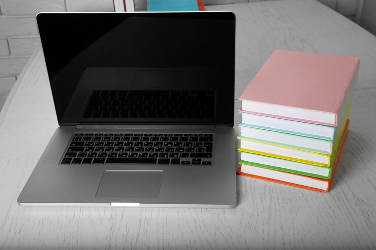 Foto pila de libros con laptop en la mesa de cerca