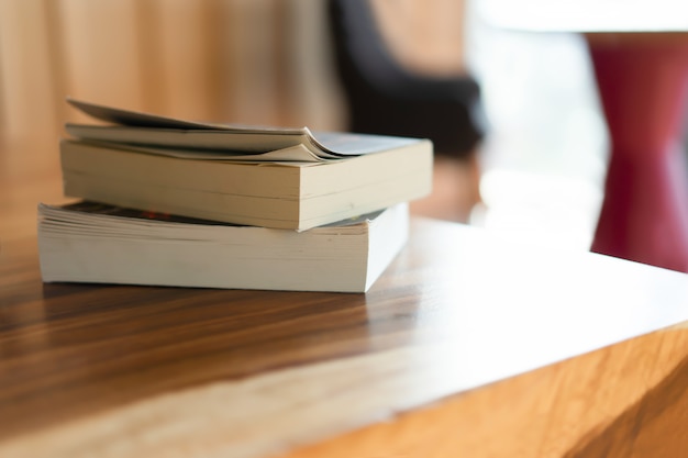 Pila de libros en mesa de madera.