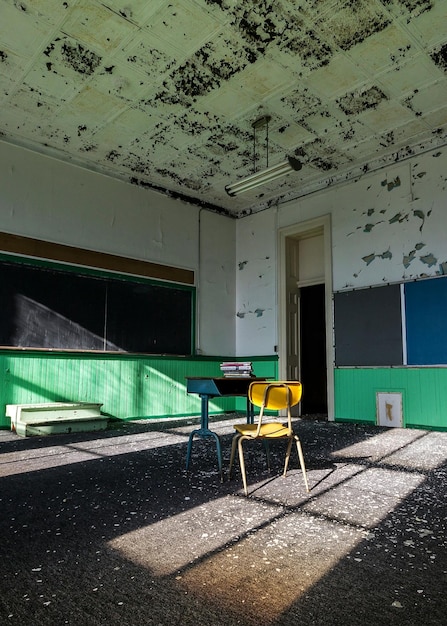 Foto una pila de libros en la mesa con una silla en un aula abandonada