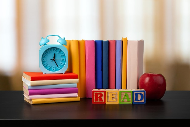 Pila de libros sobre la mesa de madera contra el fondo borroso