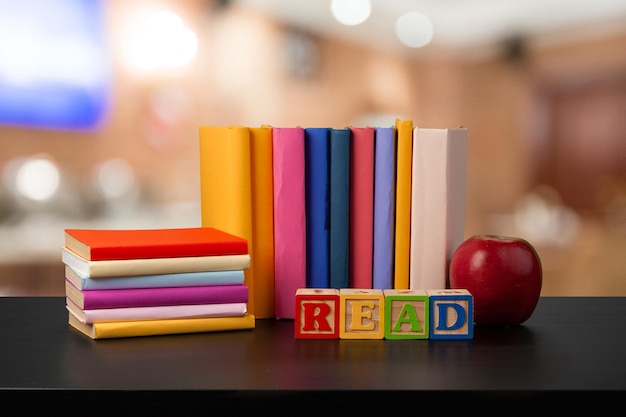 Pila de libros sobre la mesa de madera contra el fondo borroso