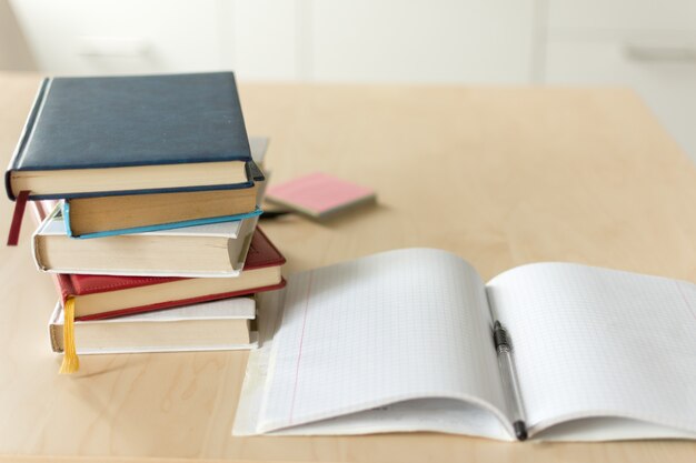 Pila de libros sobre la mesa de madera.