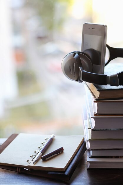 Una pila de libros de texto en el alféizar de la ventana y utensilios de escritura.