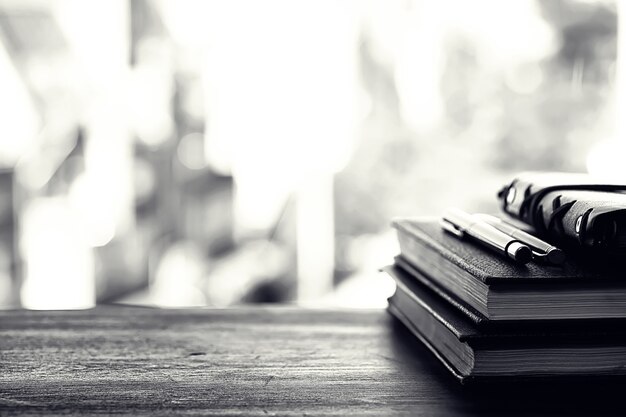 Una pila de libros de texto en el alféizar de la ventana y utensilios de escritura.