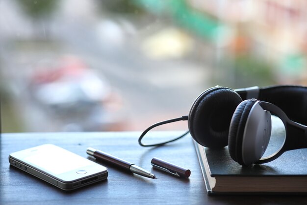 Una pila de libros de texto con auriculares negros sobre una mesa