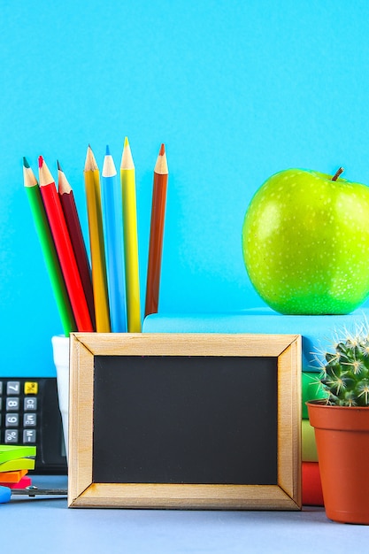 Una pila de libros y útiles escolares. Mesa de trabajo, educación, escuela.