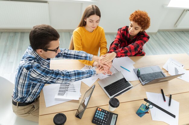 Pila de manos negocio inicio trabajo en equipo unidad concepto vista superior de jóvenes empresarios poniendo el