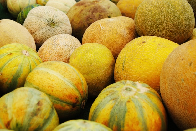 Pila de melones de agua amarilla en un mercado de agricultores