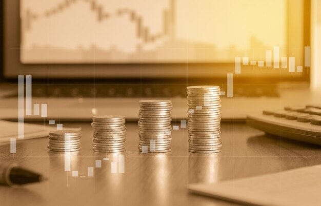 Pila de moneda de oro y computadora portátil con gráfico comercial concepto de inversión financiera