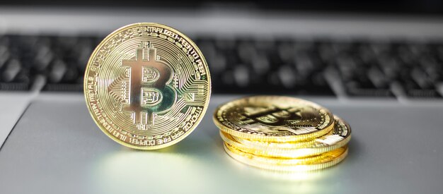 Pila de monedas de criptomoneda Bitcoin oro en el teclado del ordenador portátil