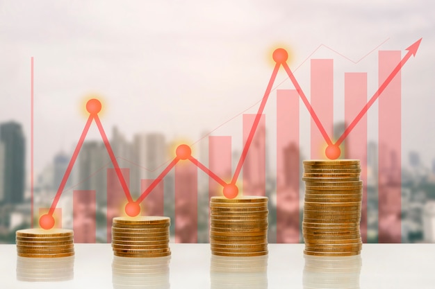 Pila de monedas de dinero con creciente gráfico y flecha hacia arriba, por concepto de negocio.