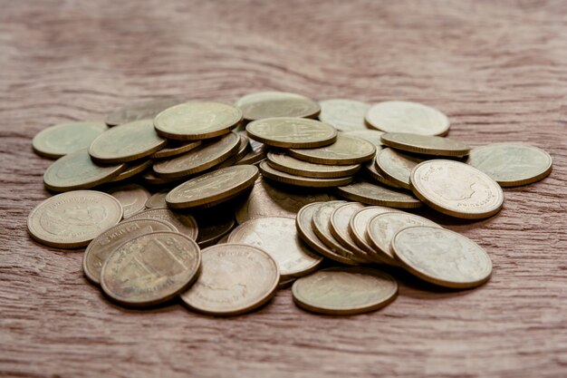 Pila de monedas en la mesa de madera.