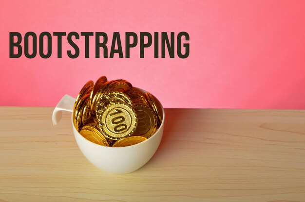 Pila de monedas en una taza con texto BOOTSTRAPPING