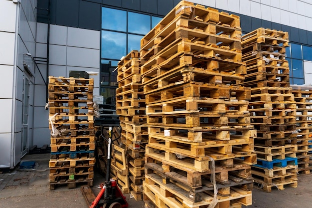 Una pila de palets de madera en un almacén interno Un área de almacenamiento de palets al aire libre bajo el techo junto a la tienda Montones de palets de carga Eurotype en una instalación de reciclaje de residuos