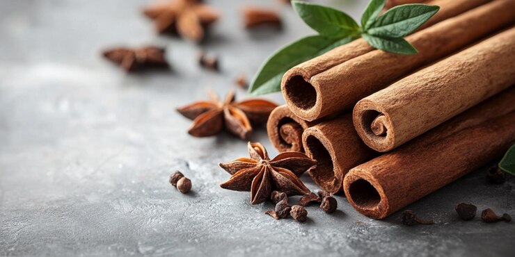 una pila de palos de canela con ramas en la parte superior