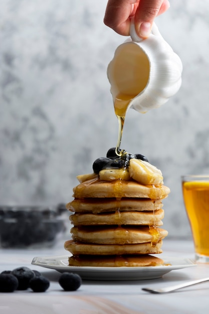 Pila de panqueques con arándanos frescos y miel. Deliciosos pasteles para el desayuno.