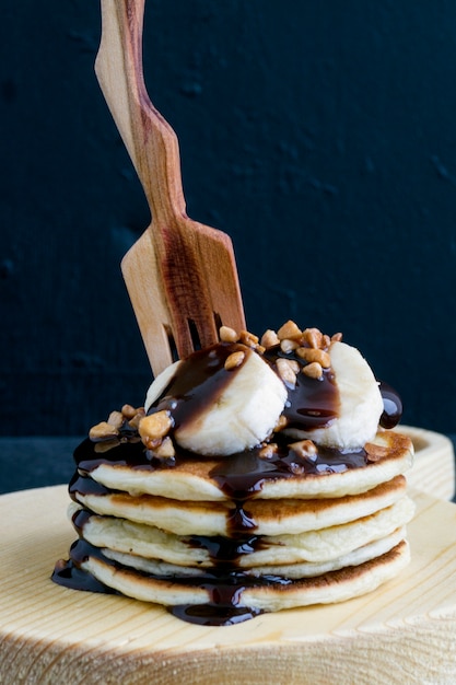 Pila de panqueques con salsa de plátano y chocolate.