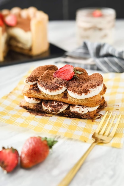 Una pila de pasteles de tiramisú con fresas encima