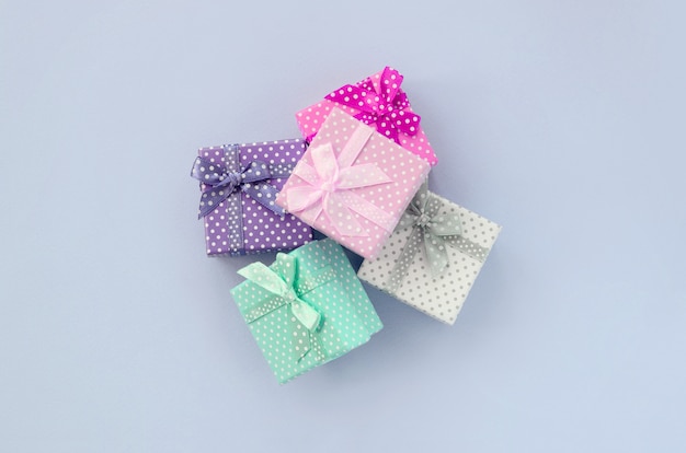 La pila de un pequeño color cajas de regalo con cintas se encuentra en una violeta