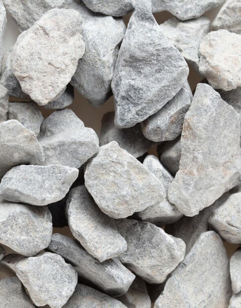La pila de piedra de construcción de grava se encuentra en el grupo de piedra de grava de roca gris muestra de cerca la textura y el diseño del objeto de polvo Fondo blanco aislado disparo de congelación