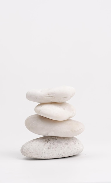 Una pila de piedras blancas aisladas sobre un fondo blanco Pirámide de piedras Concepto de equilibrio y armonía de la vida vertical