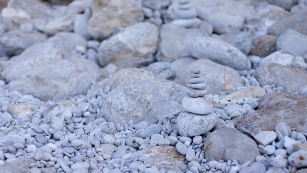 Pila de piedras de guijarros de equilibrio con piscina fuera de foco para el fondo