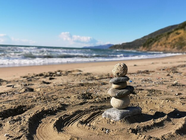 Foto una pila de piedras en la playa contra el cielo