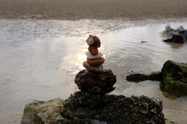 Foto pila de piedras en la roca en la playa