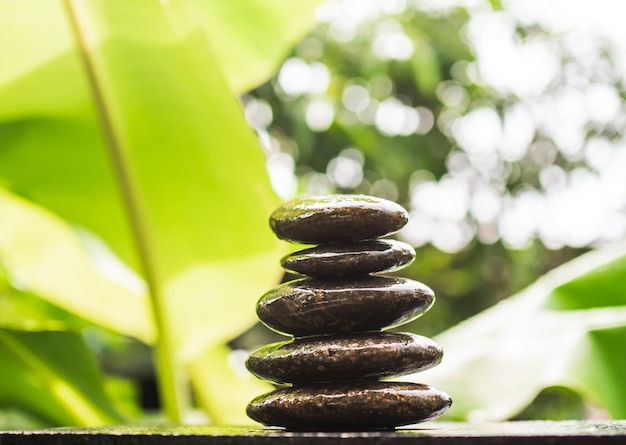 Pila pirámide piedra zen guijarros naturaleza en madera con desenfoque verde nater al aire libre meditación tranquila calma todavía equilibrio relajación de budismo religión o aromaterapia spa masaje setzen jardín concepto