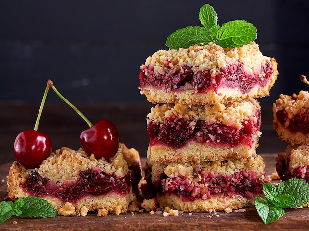 Pila de rebanadas cuadradas de un pastel con cereza roja