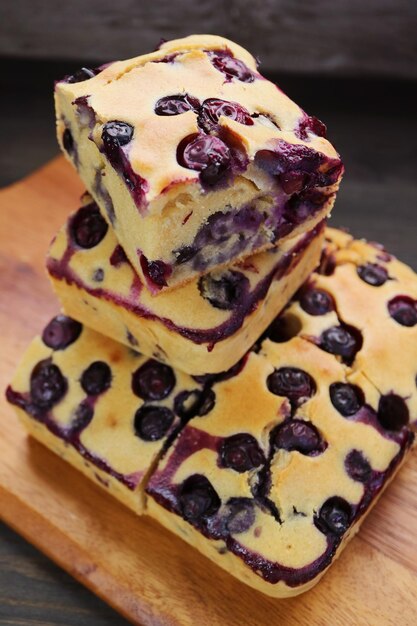 Foto una pila de rebanadas de pastel de arándanos recién horneados en una tabla de pan de madera