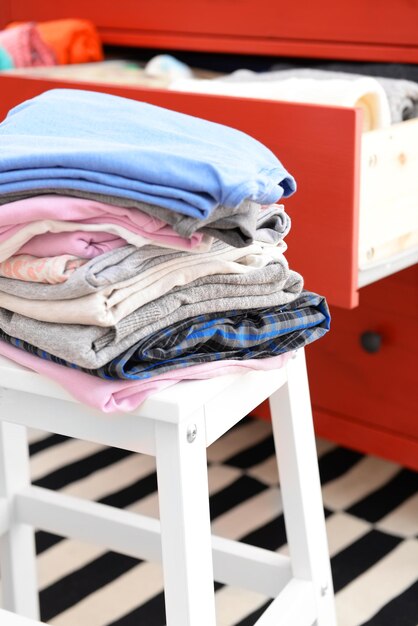 Foto una pila de ropa plegada en un taburete de madera en primer plano