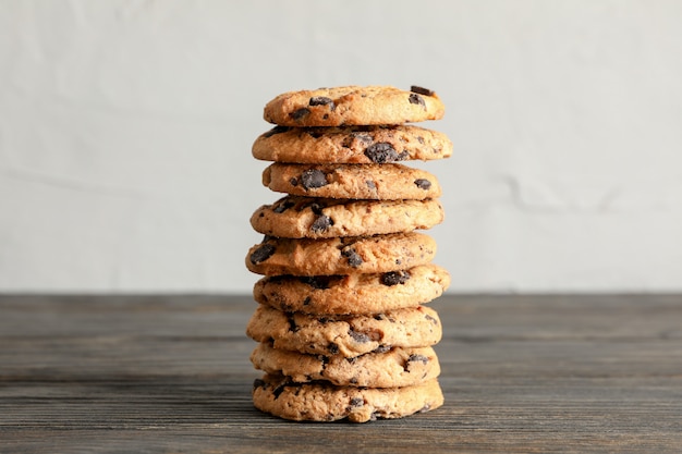 Pila de sabrosas galletas de chispas de chocolate en la mesa de madera. Espacio para texto