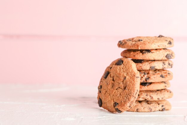 Pila de sabrosas galletas de chispas de chocolate sobre fondo de madera. Espacio para texto