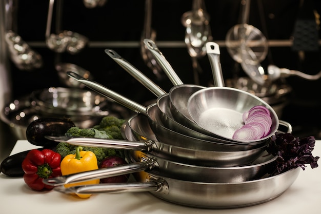 Foto pila de sartenes de cocina profesionales. utensilios de cocina de restaurante. concepto de alimentación saludable y nutrición adecuada.