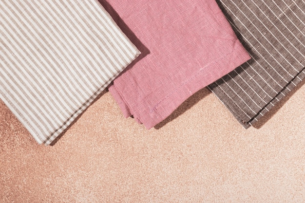 Pila de servilletas de tela de color beige sobre fondo enlucido