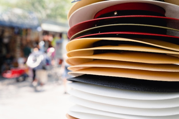 Pila de sombreros de paja en la tienda de la calle. Hombres accesorios coloridos apilados, conceptos de recuerdo