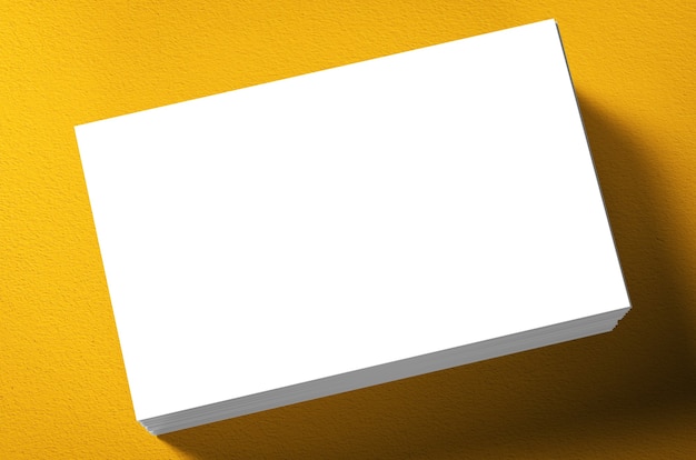 Pila de tarjetas de presentación en blanco sobre fondo amarillo