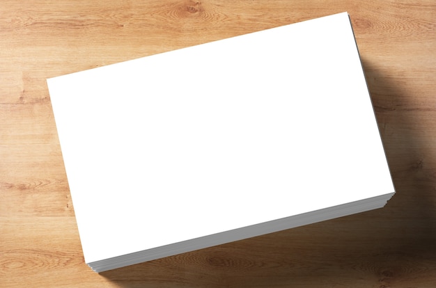 Pila de tarjetas de presentación en blanco sobre fondo de madera